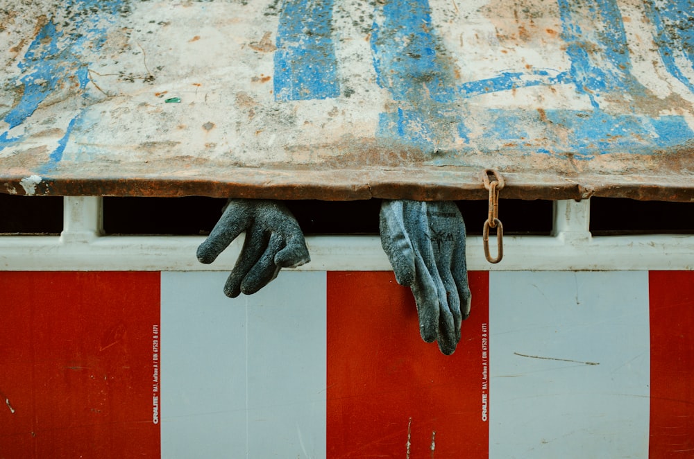 a pair of gloves hanging from the side of a building