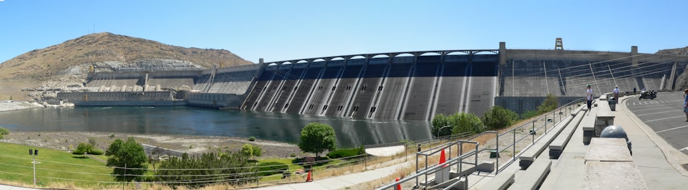 a man riding a bike down a road next to a dam