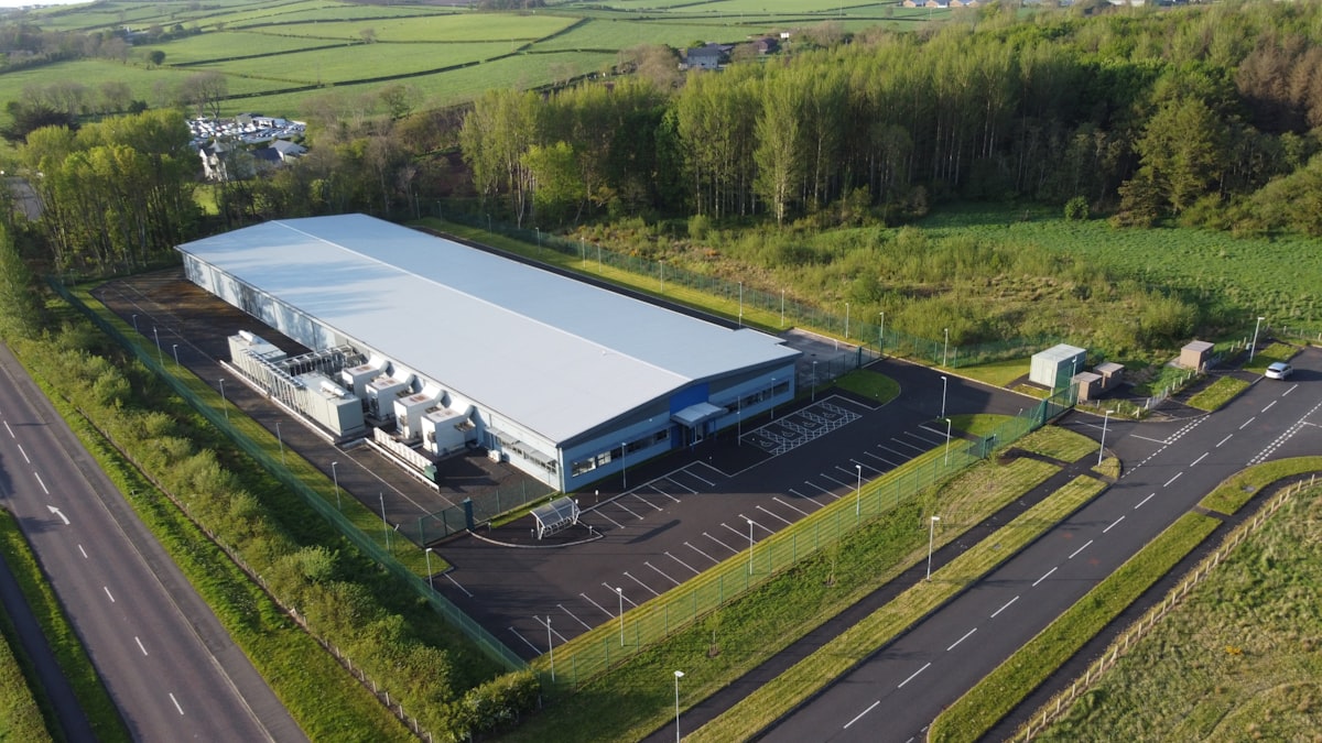 Luchtfoto van een groot datacentergebouw in een open landschap.