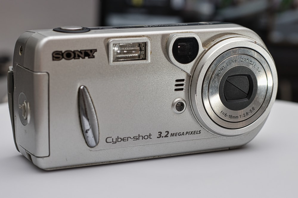 a silver camera sitting on top of a white table