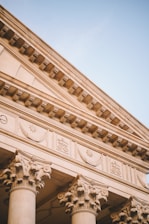 a close up of a building with columns and a clock
