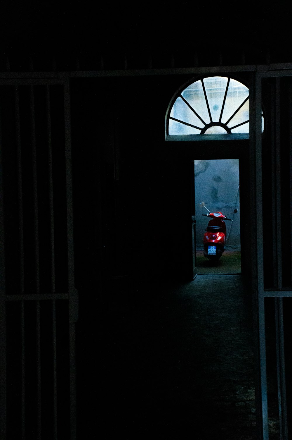 a dark hallway with a motorcycle parked in the doorway