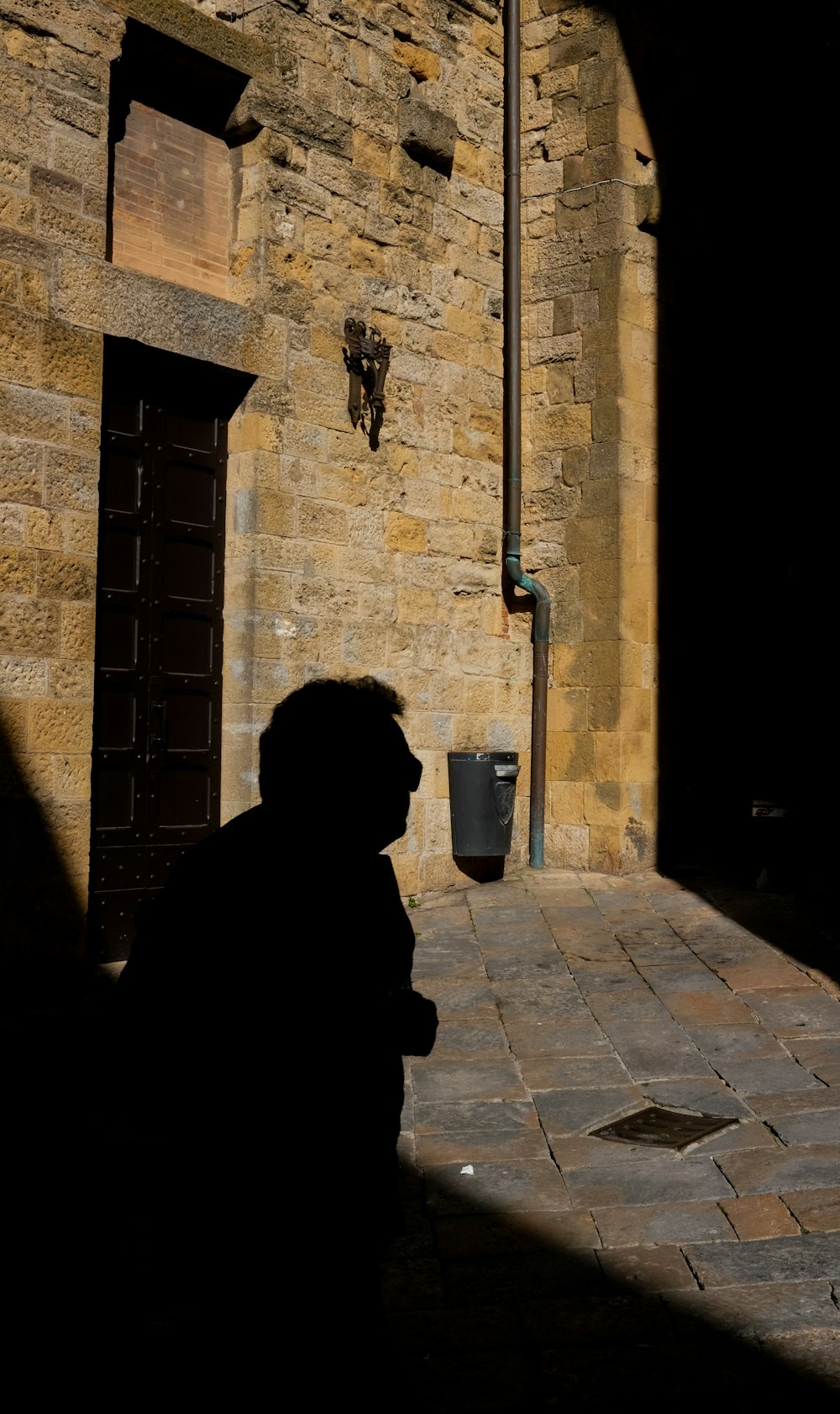 a man standing in front of a stone building