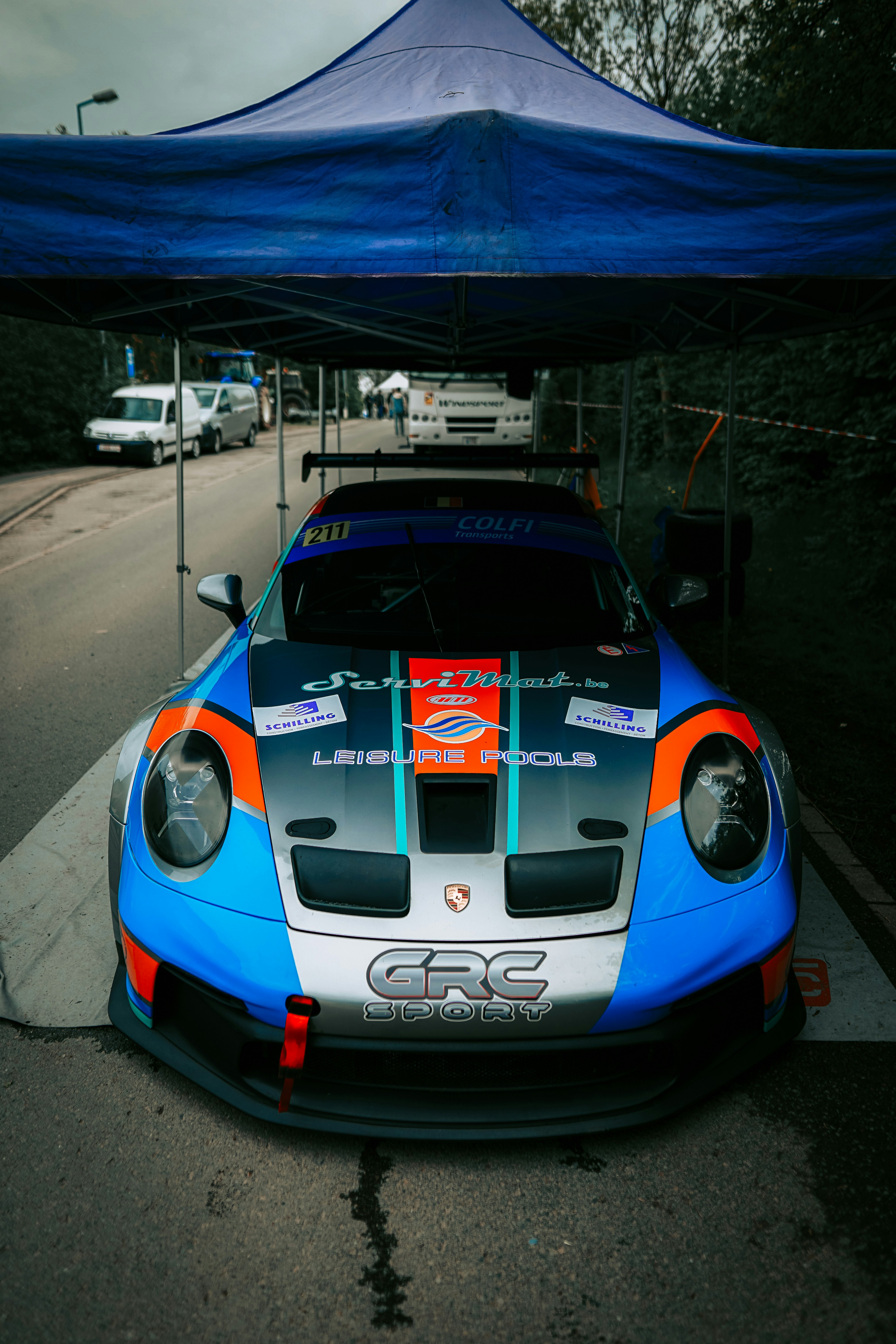 a blue and orange sports car parked under a tent