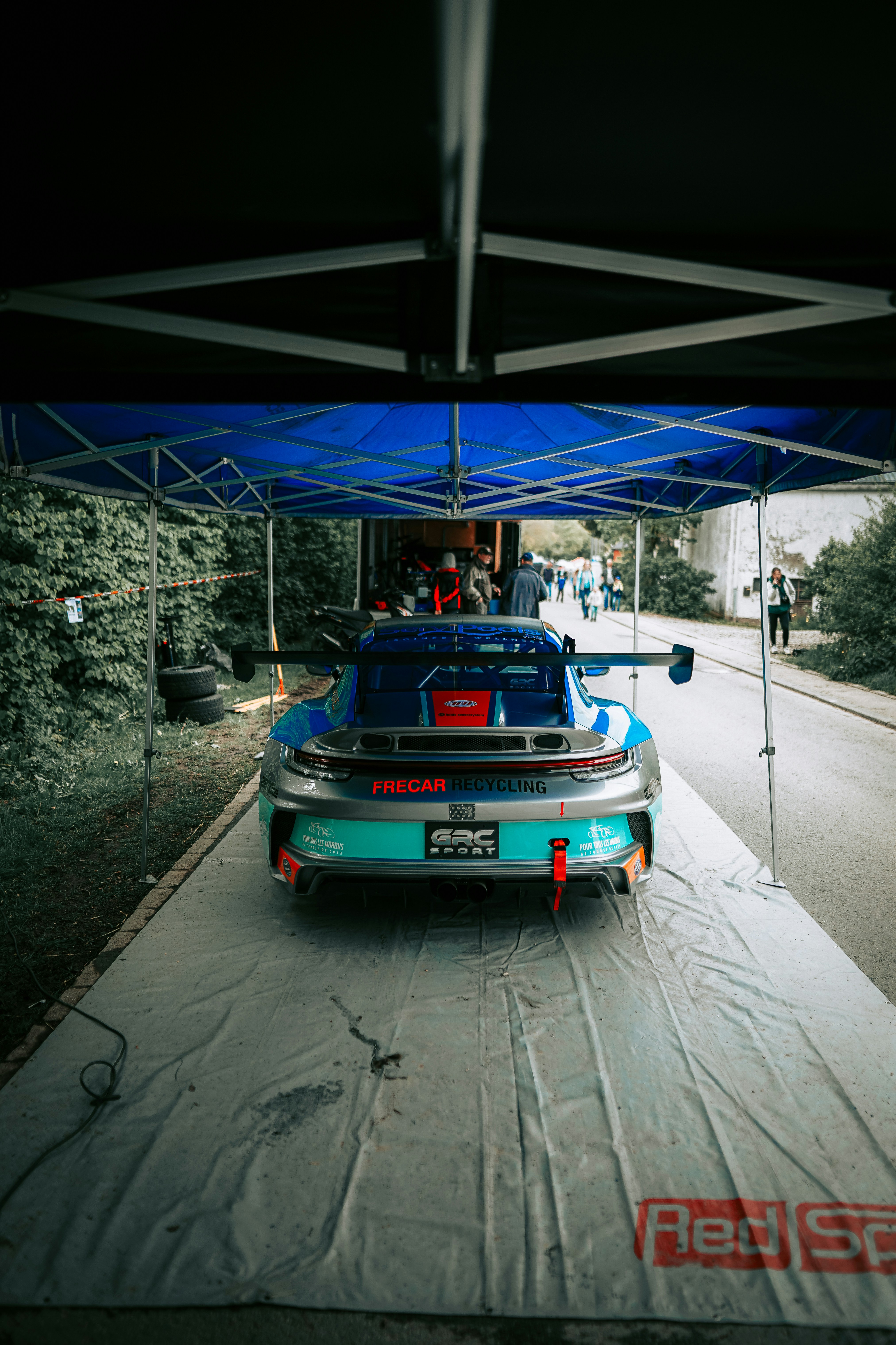 a car is parked under a tent on the side of the road