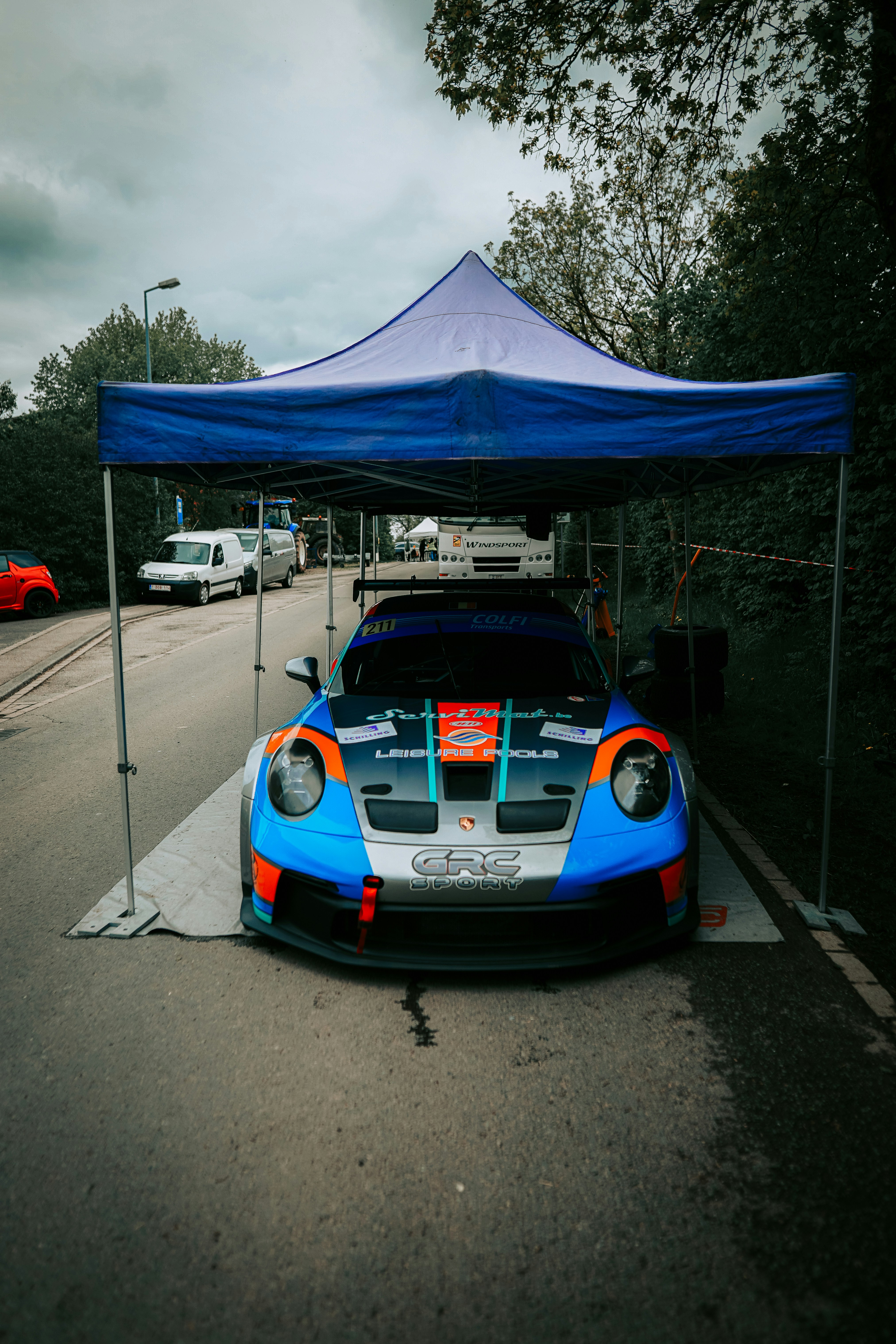 a blue and orange sports car under a blue tent