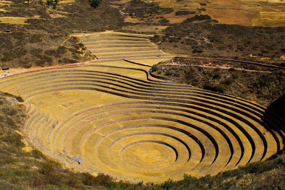 an aerial view of a large circular structure in the middle of a field