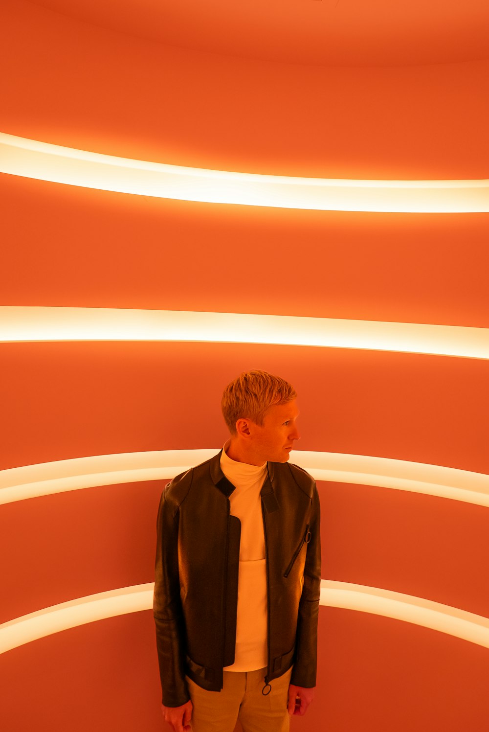 a man standing in front of a red wall