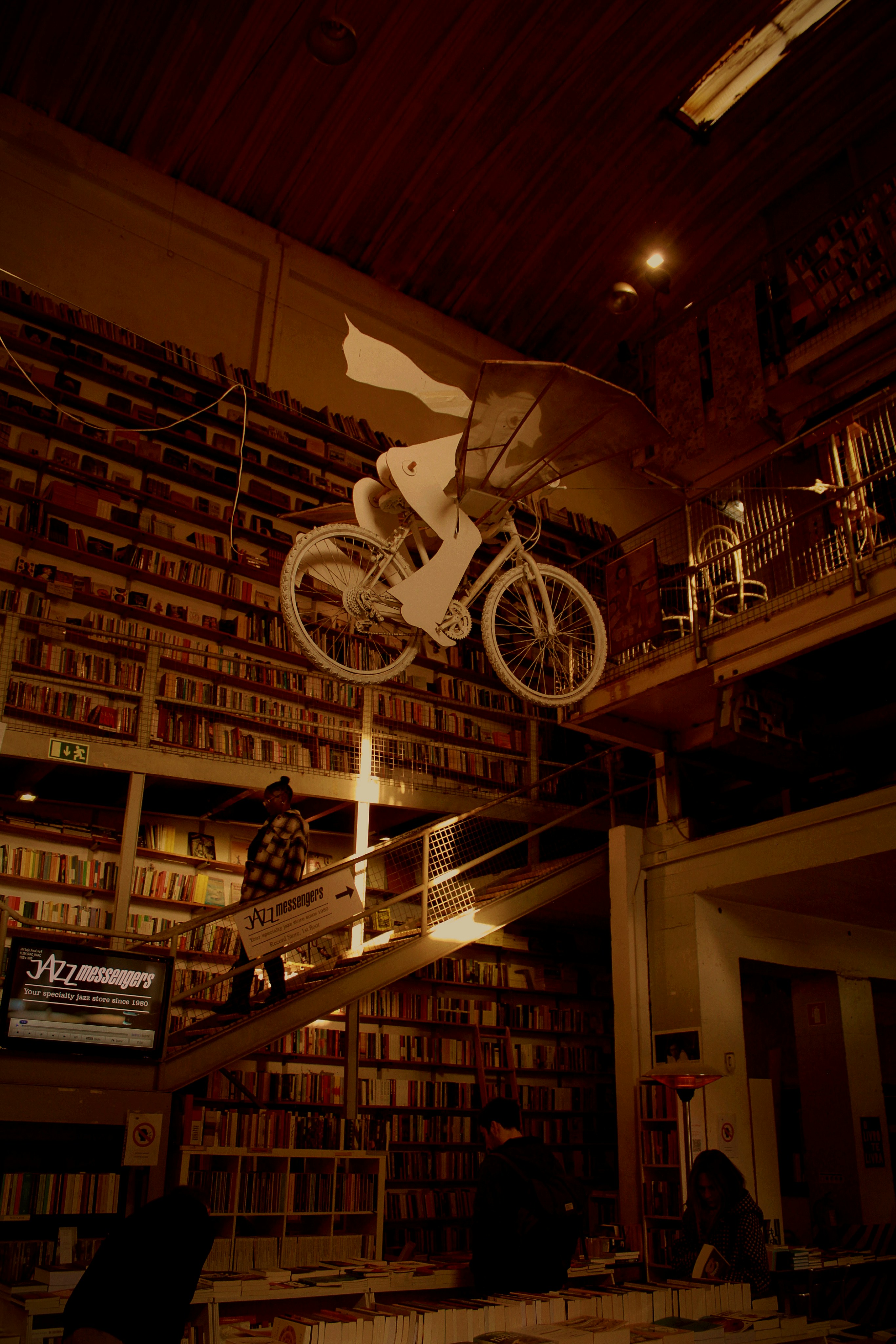 a bicycle suspended from the ceiling of a library