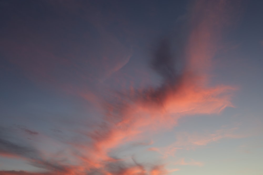 a sunset view of a beach with a surfboard in the foreground