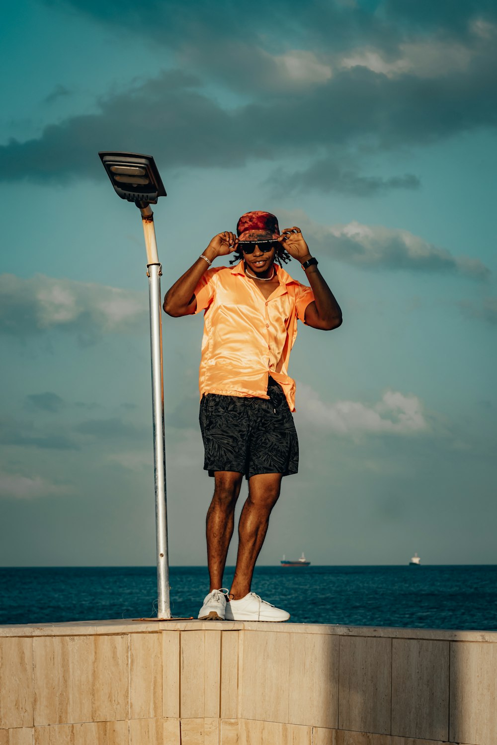 a man standing on top of a wall next to the ocean