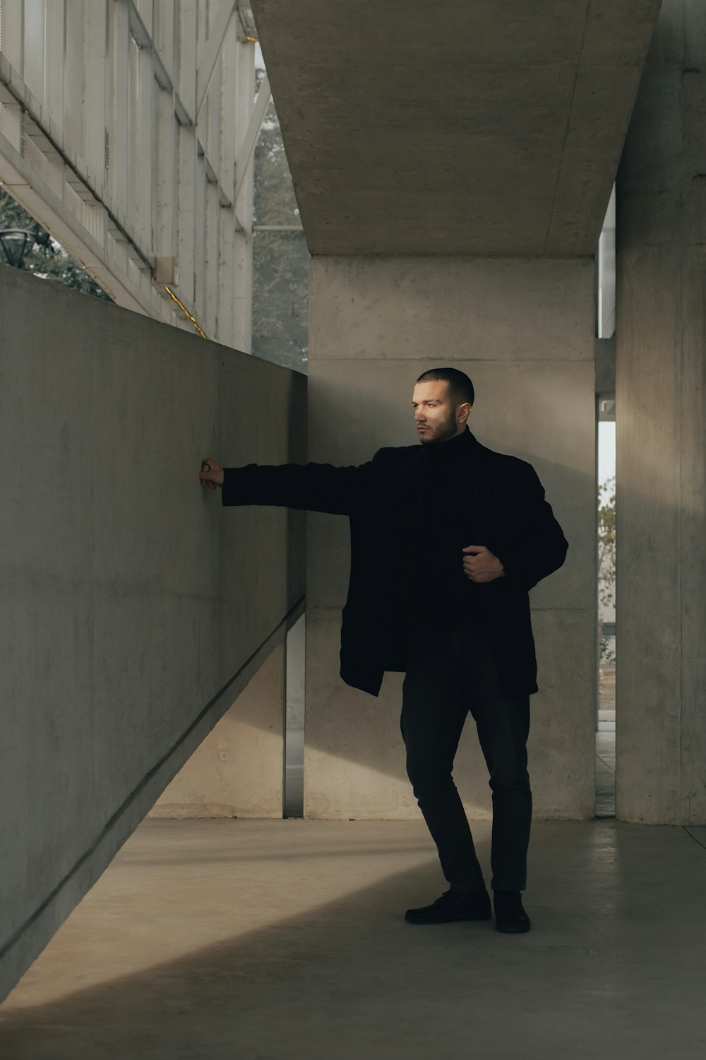 a man leaning against a wall in a building