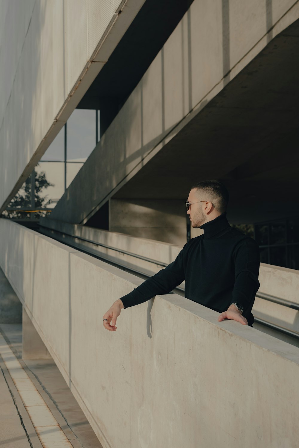 a man leaning against a wall with his hands on his hips