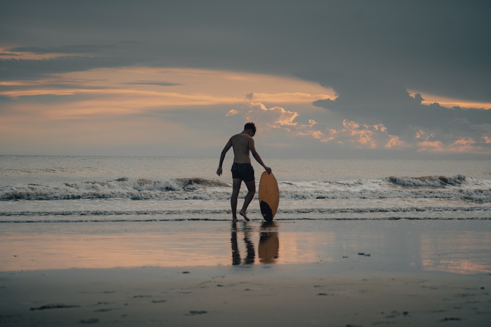 a man holding a surfboard on top of a beach