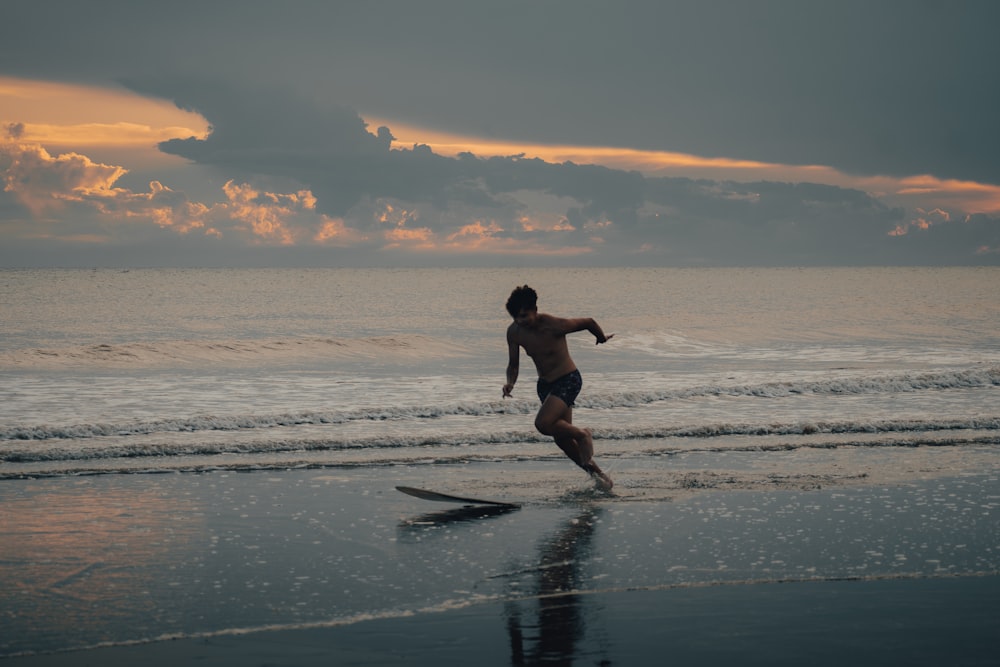 a man running on the beach at sunset