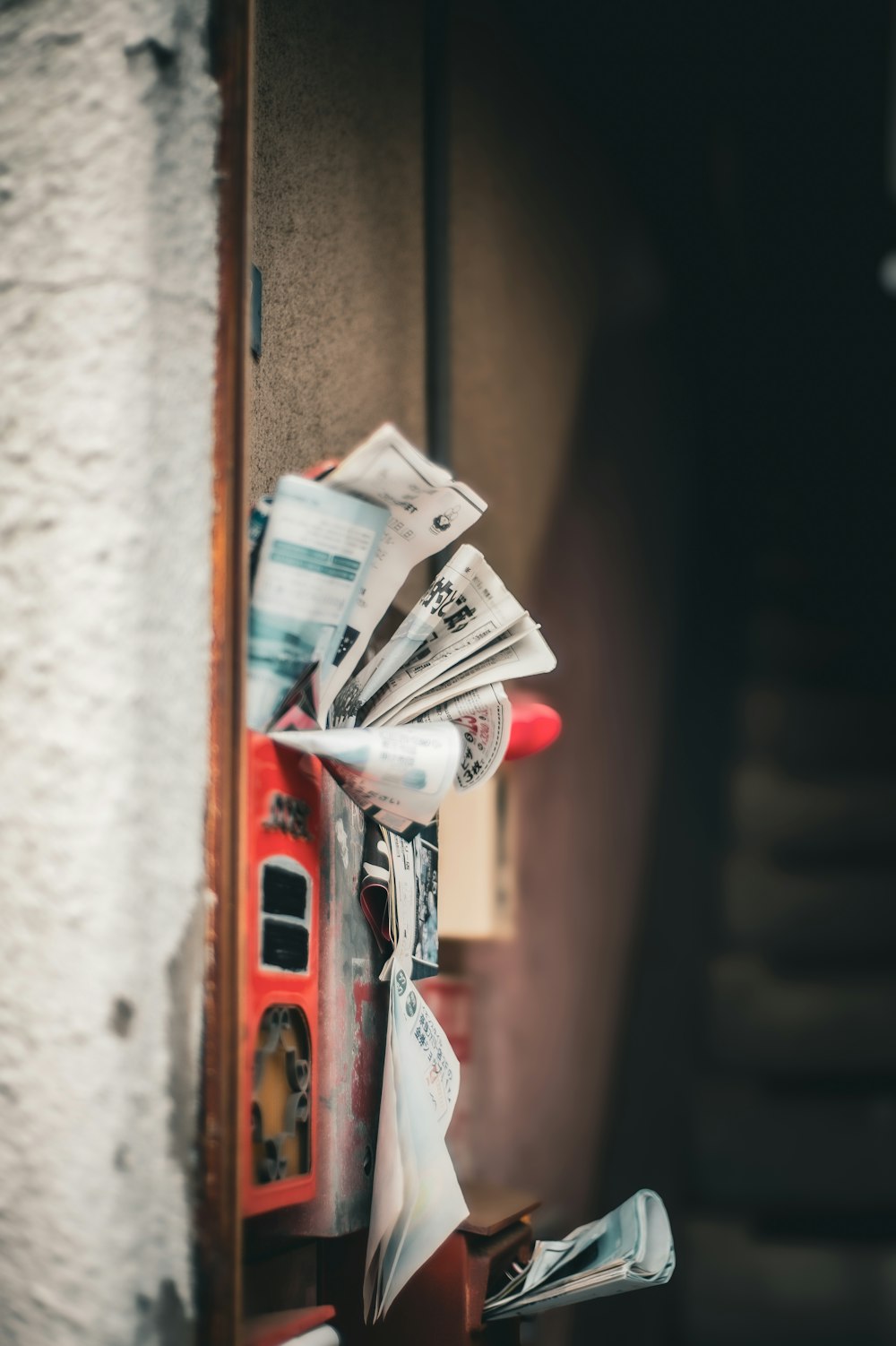 a pile of newspapers sitting on top of a wooden shelf