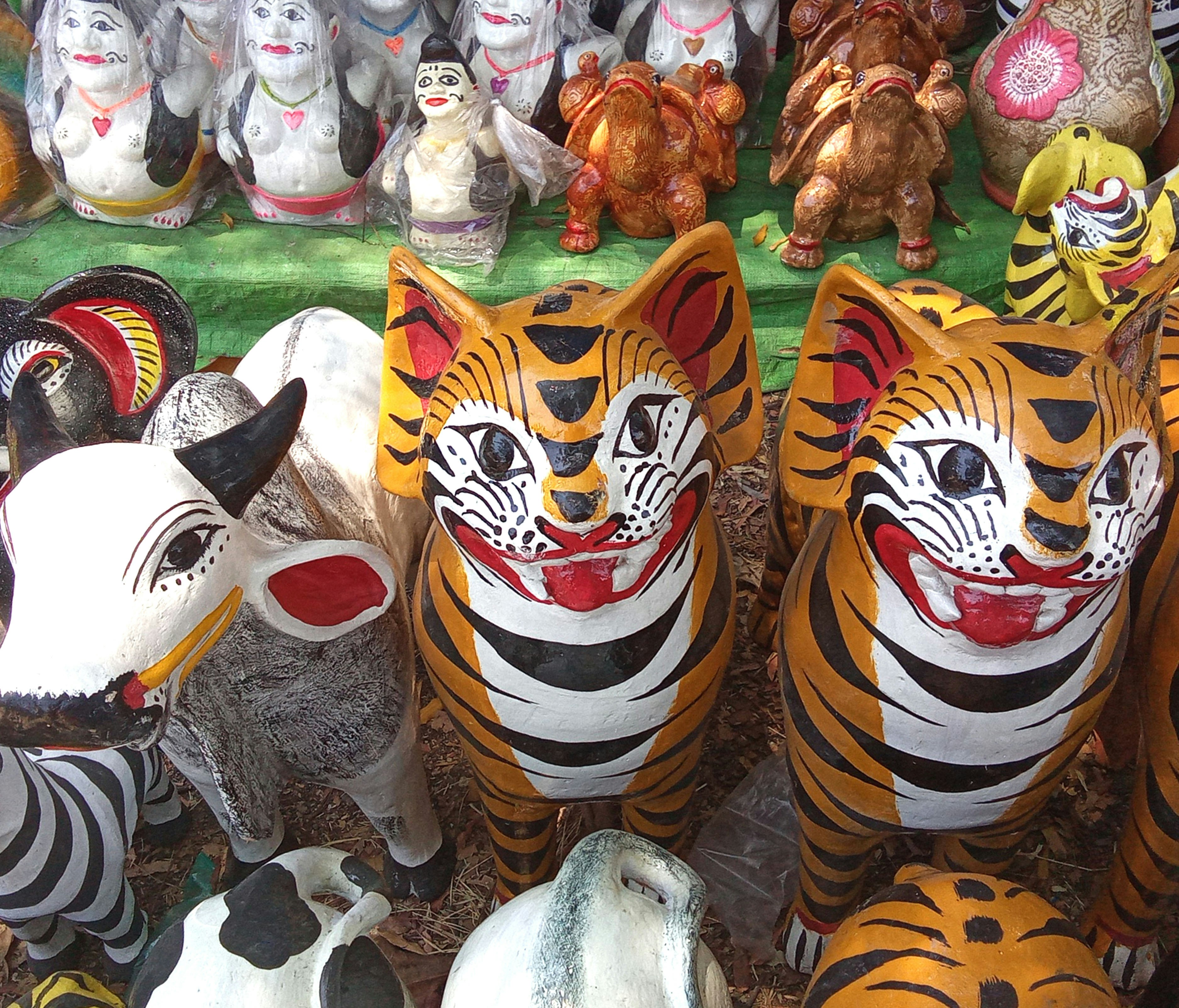 Traditional handmade pottery in the shape of tigers and cows