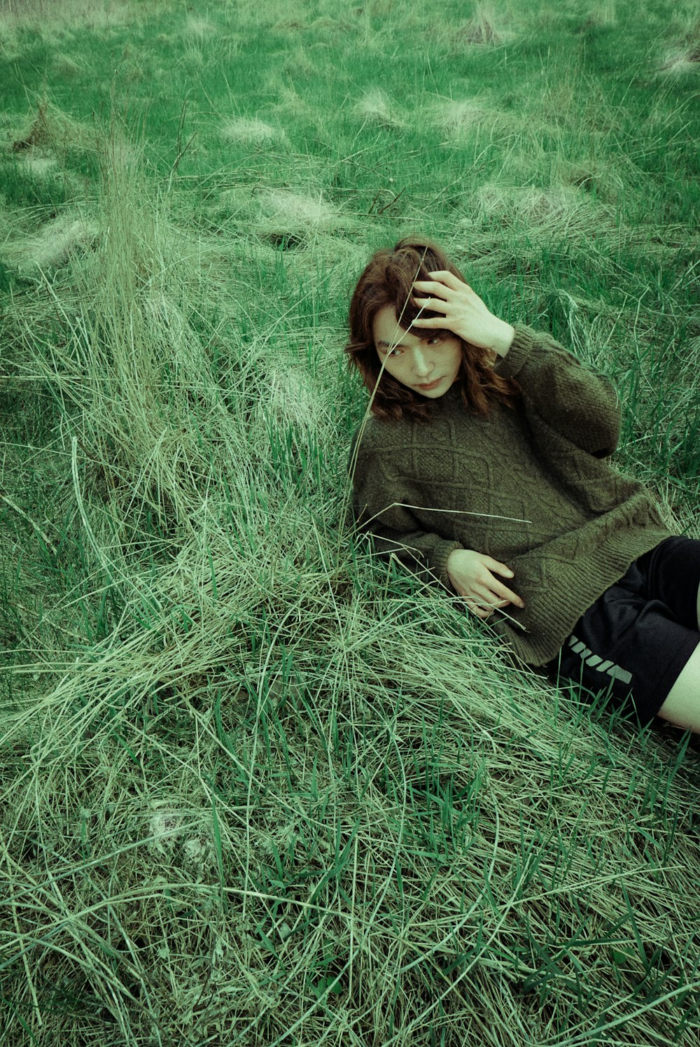 a woman laying in a field of grass