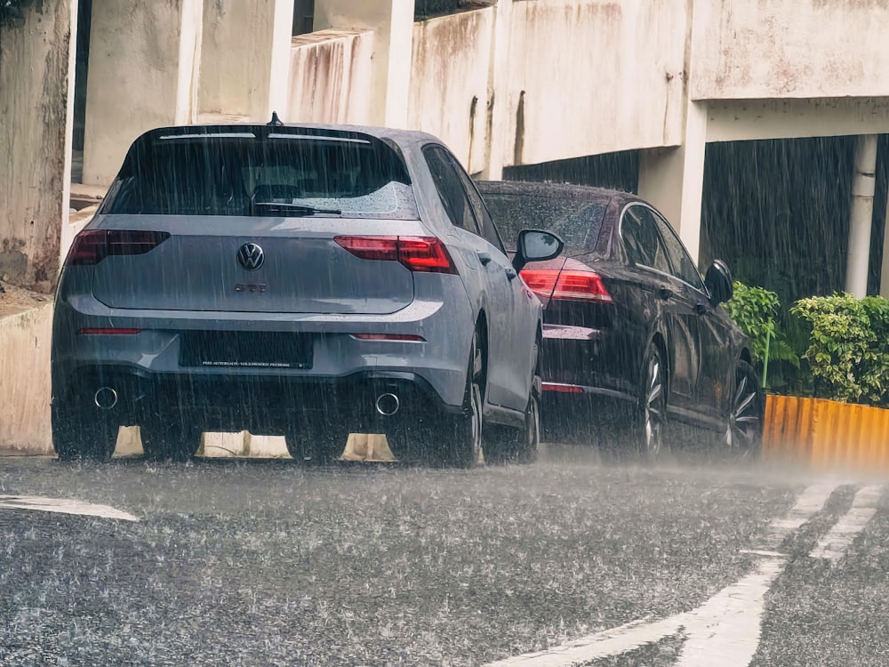 a couple of cars that are parked in the rain