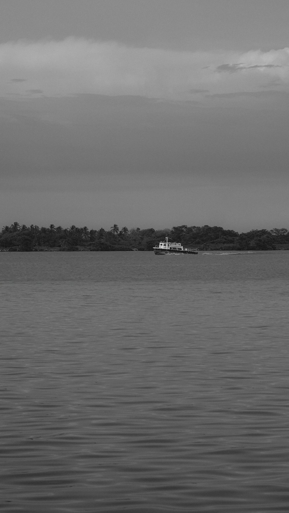 a large body of water with a boat in the distance