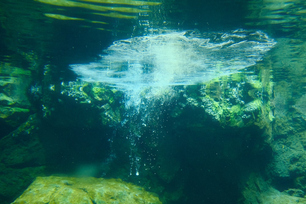 an underwater view of a rock formation in the water