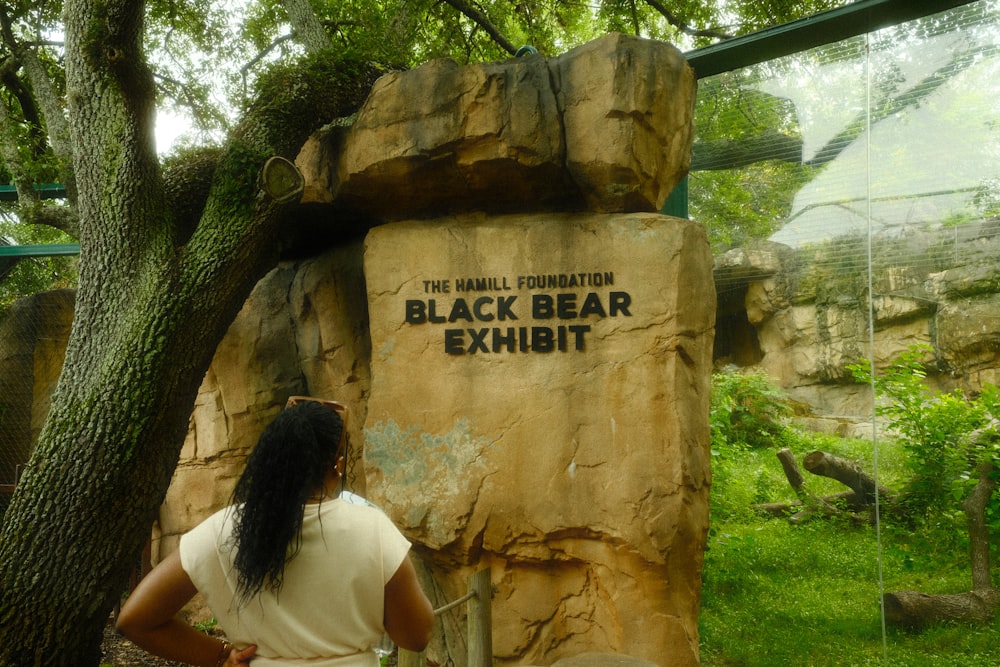 a woman standing in front of a black bear exhibit