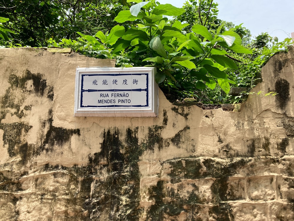 a sign on the side of a stone wall
