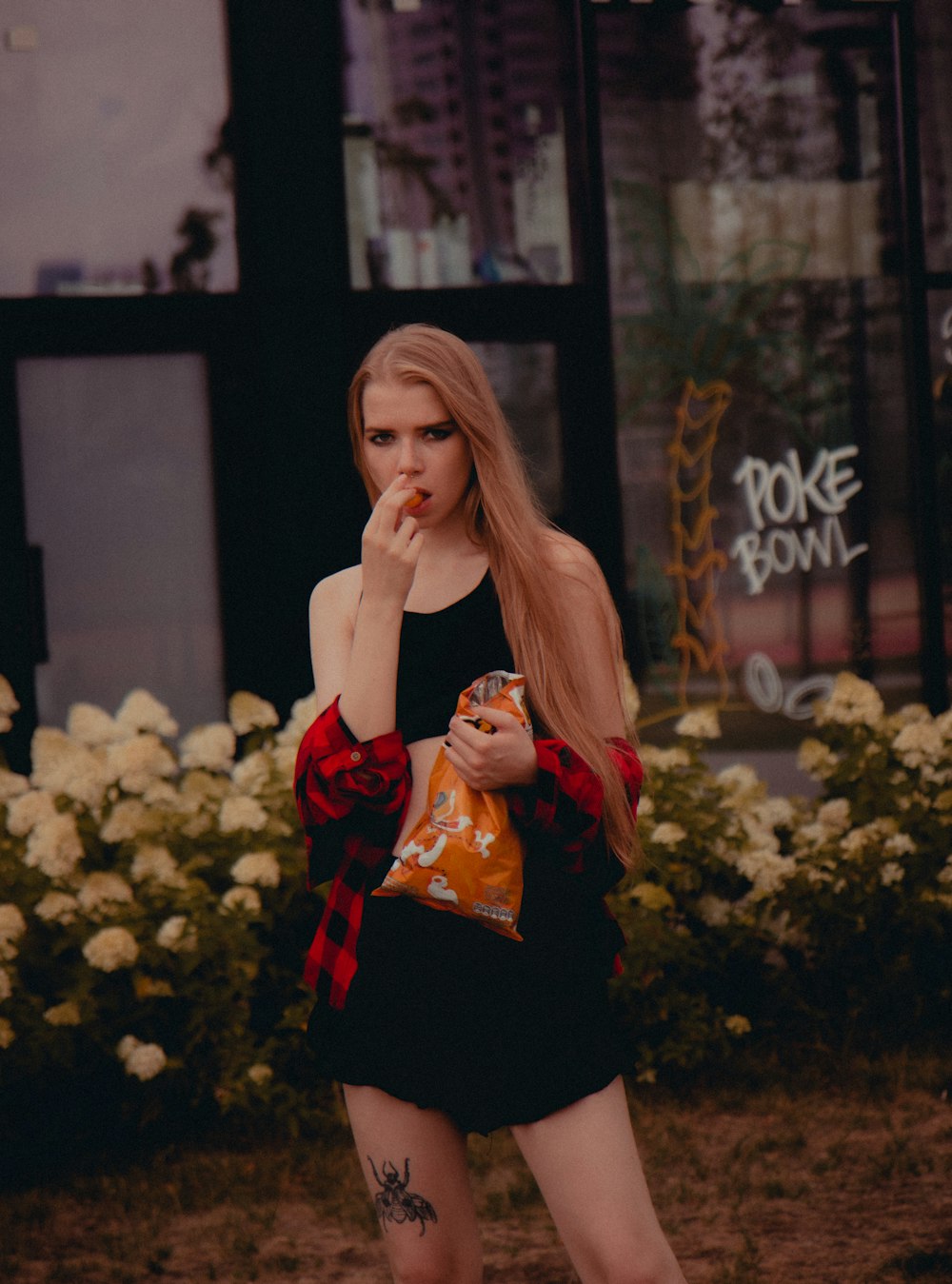 a woman standing in front of a building holding a bag