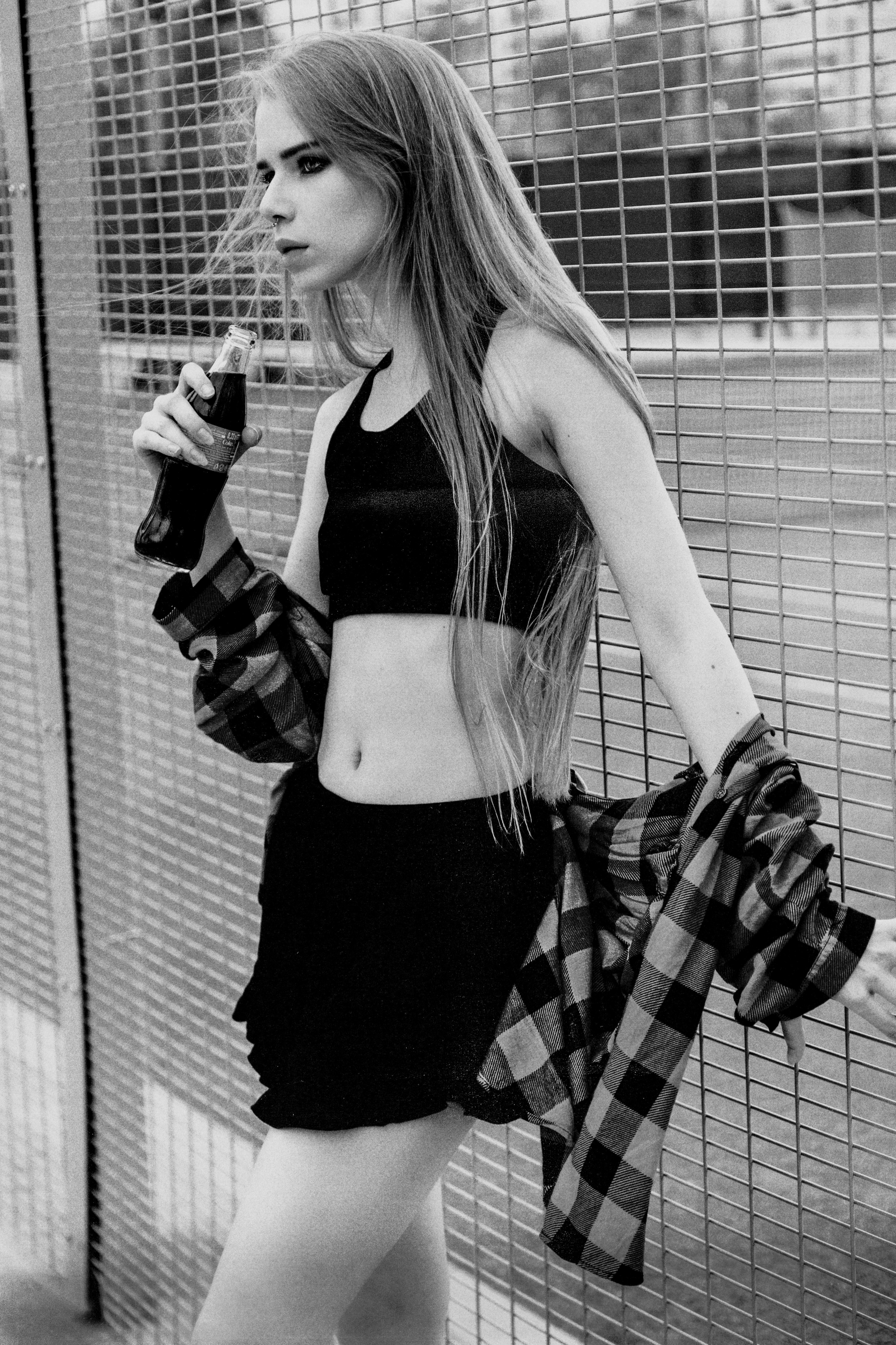 a woman in a short skirt holding a drink