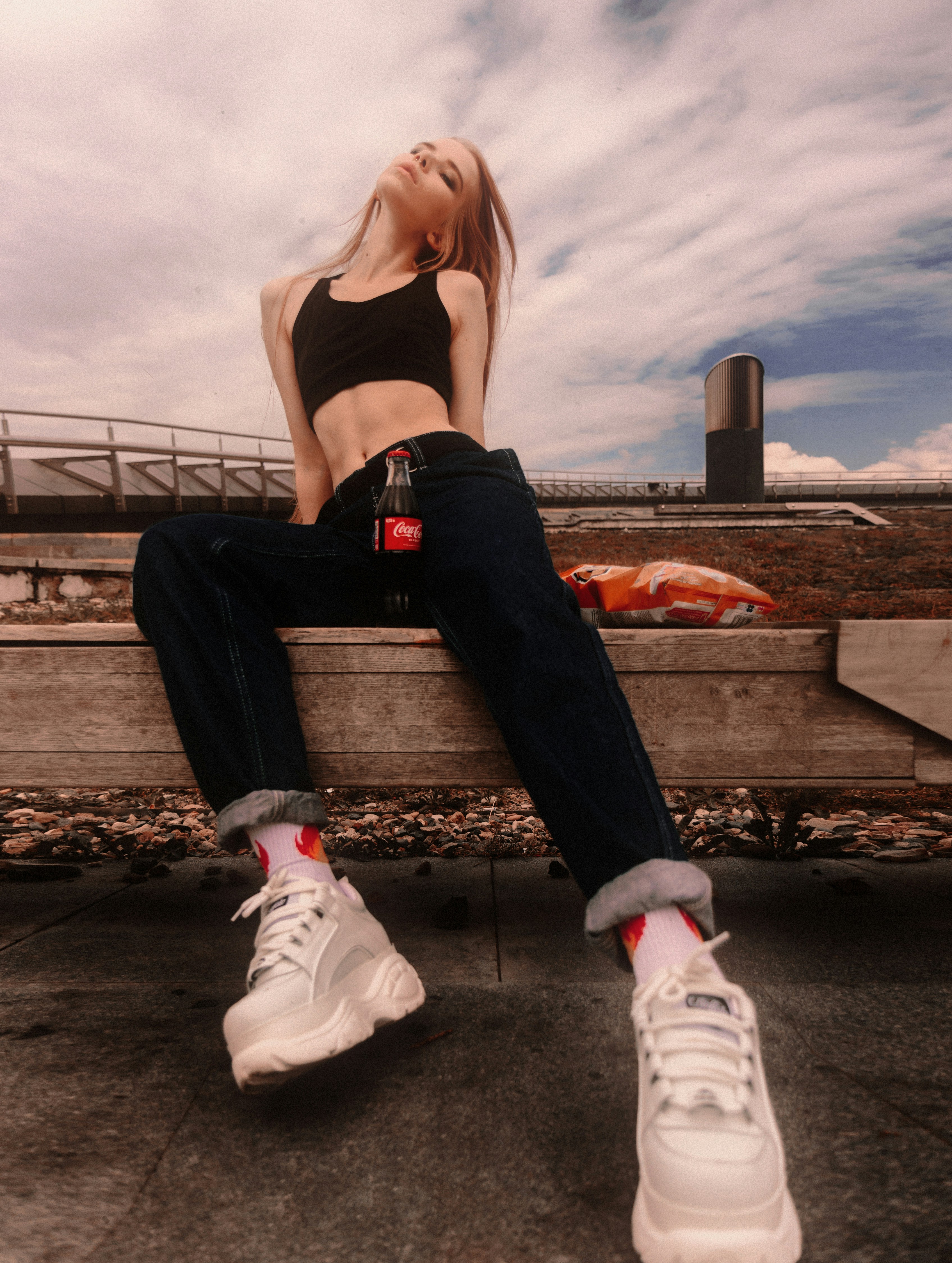 a woman sitting on top of a wooden bench