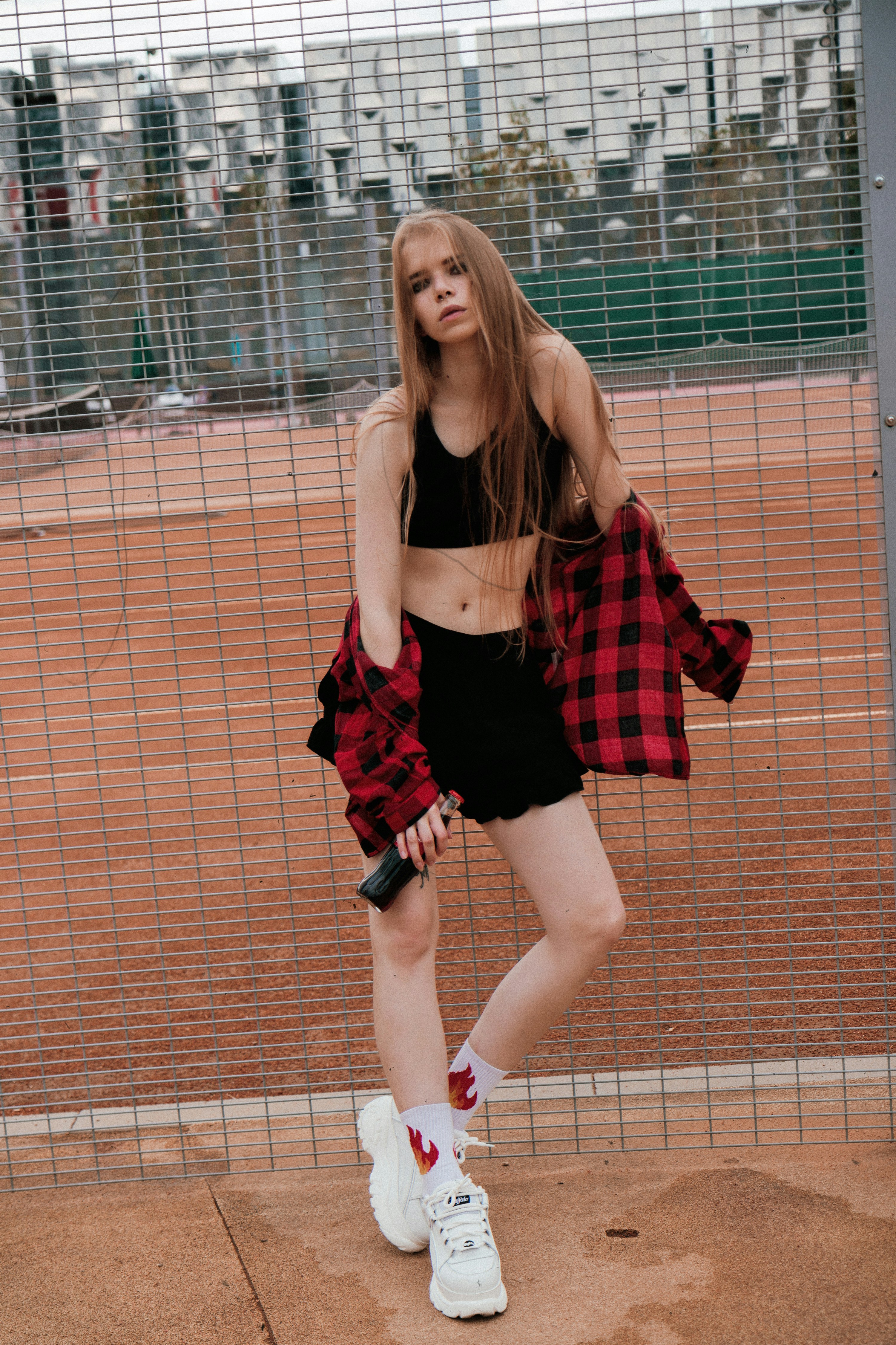a woman standing in front of a fence