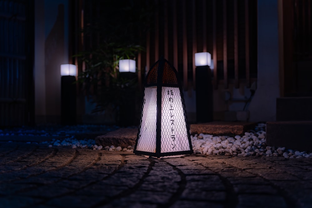 a street light sitting on top of a cobblestone road