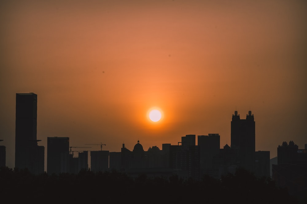 the sun is setting over a city skyline