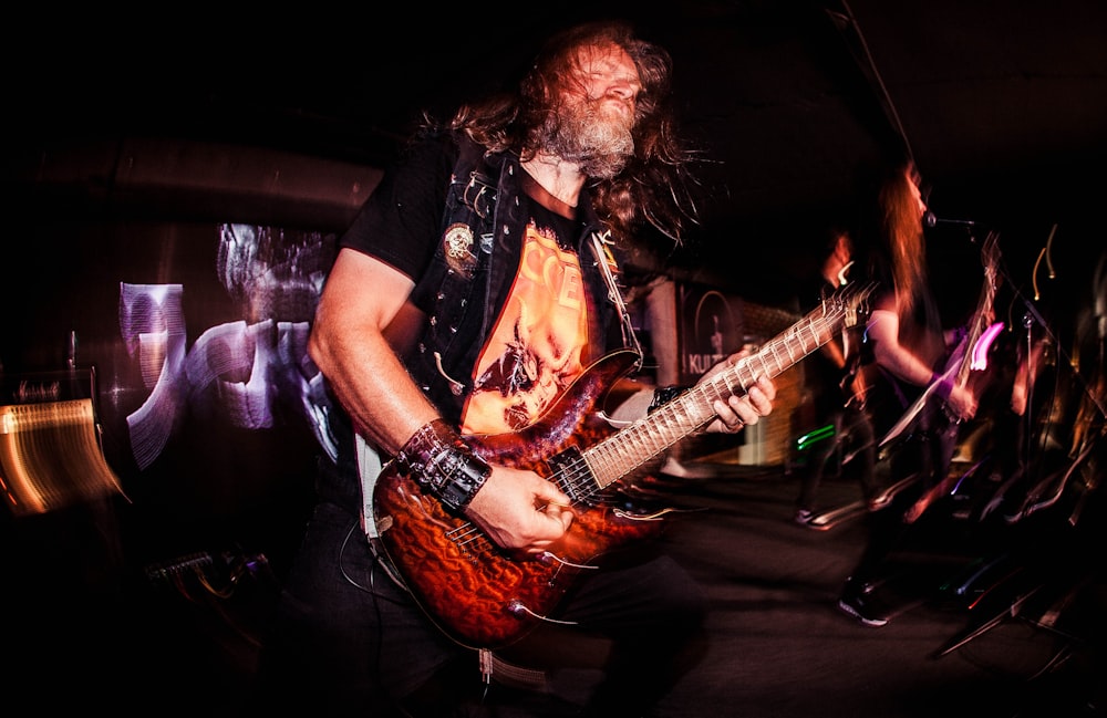 a man with a beard playing a guitar