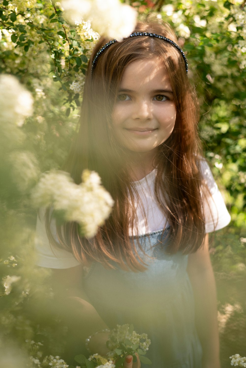 a young girl standing in a field of flowers