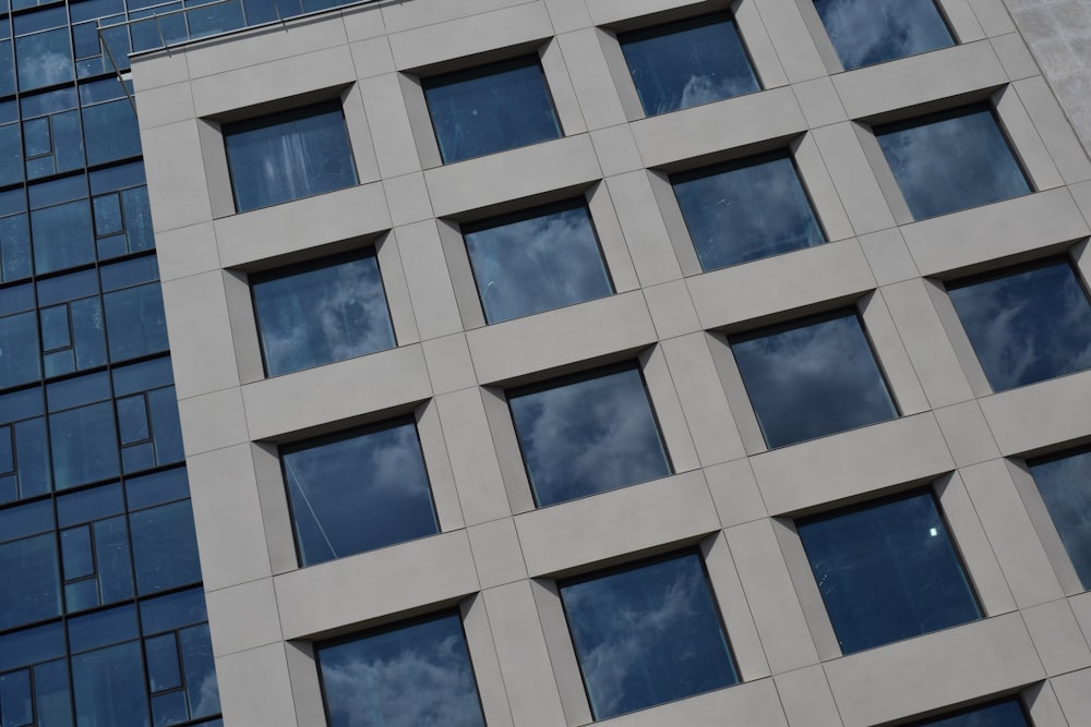 a tall building with lots of windows next to a sky background