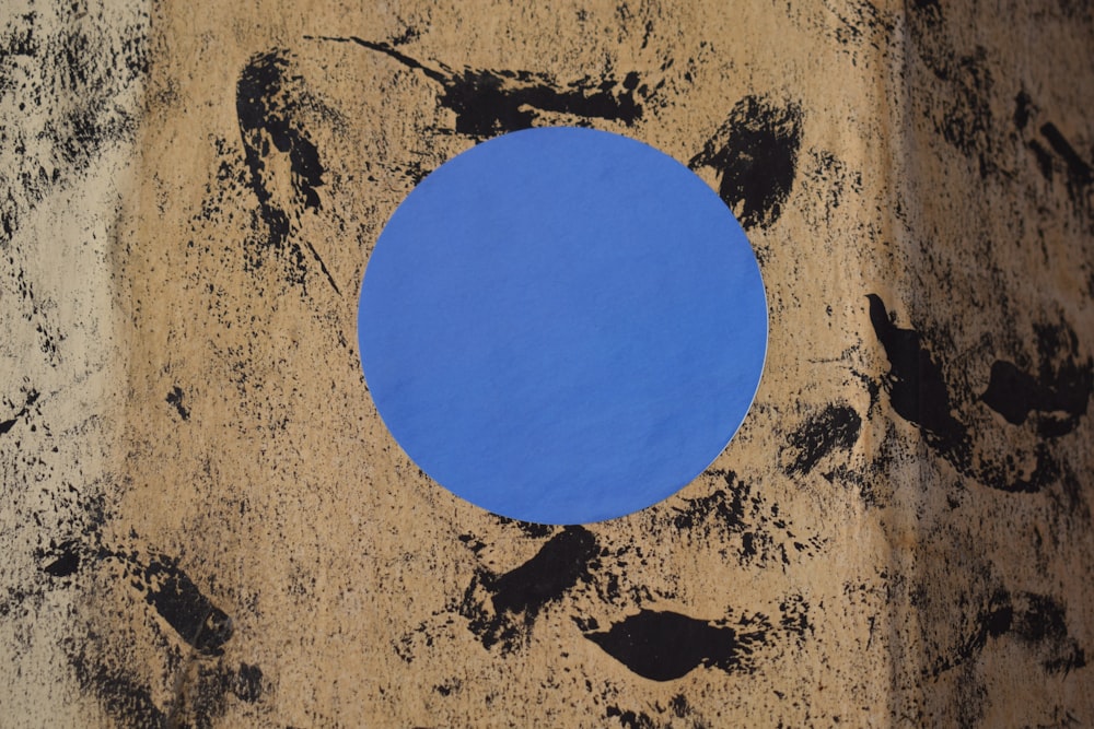 a blue circle sitting on top of a sandy beach