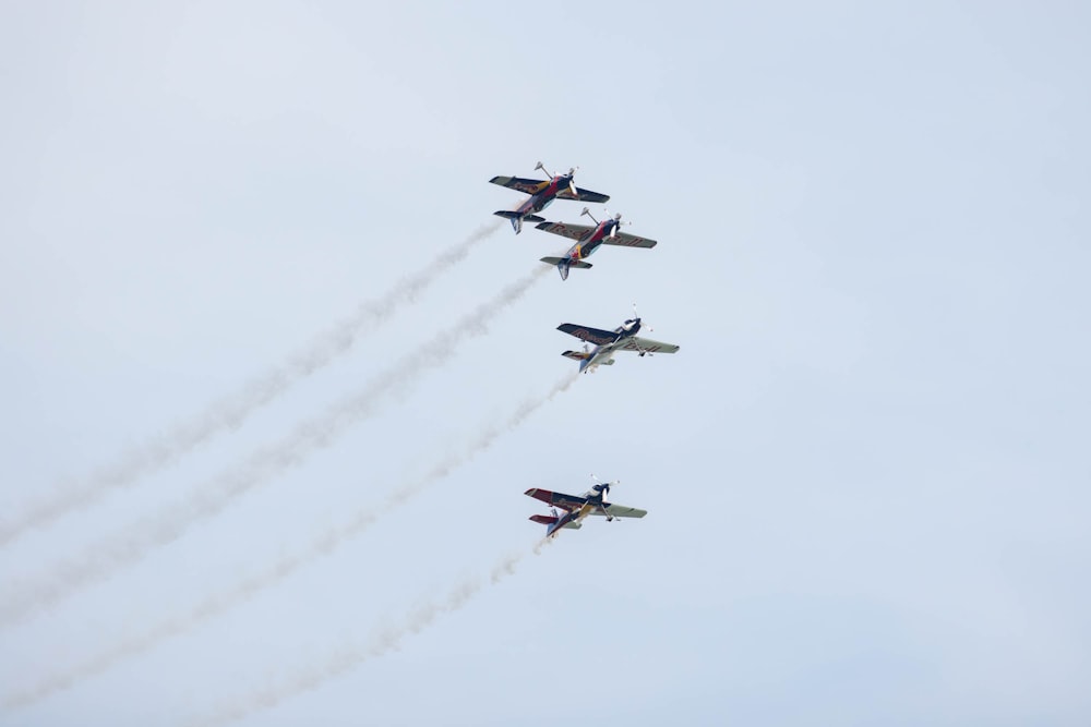 a group of airplanes flying through a blue sky