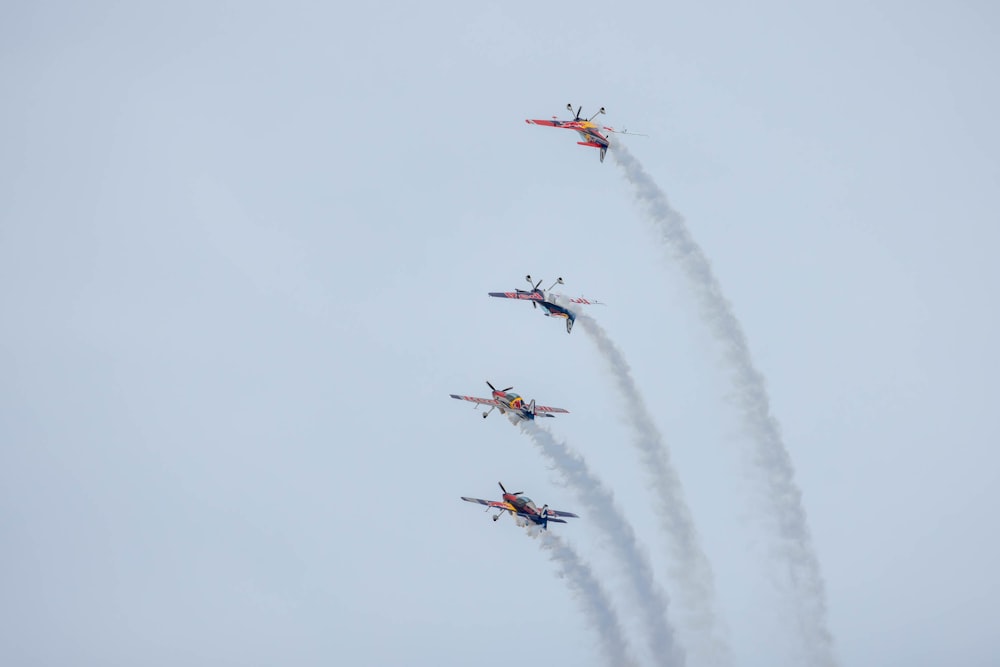 a group of fighter jets flying through a cloudy sky