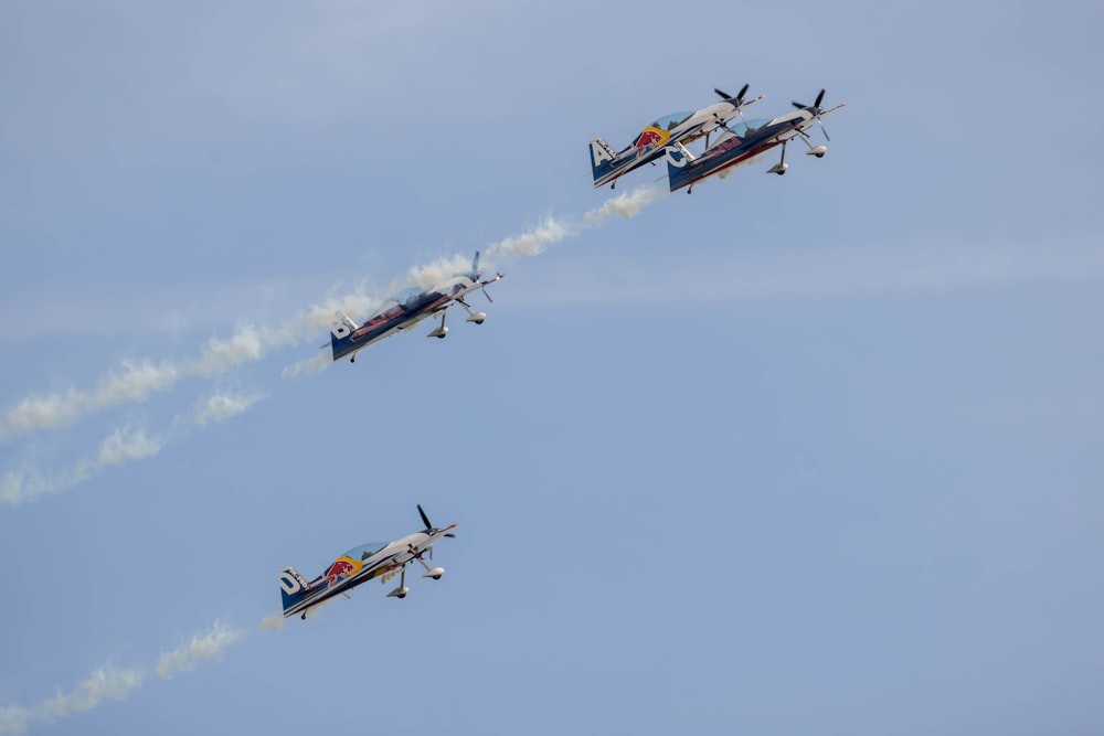 three airplanes flying in the sky with smoke coming out of them