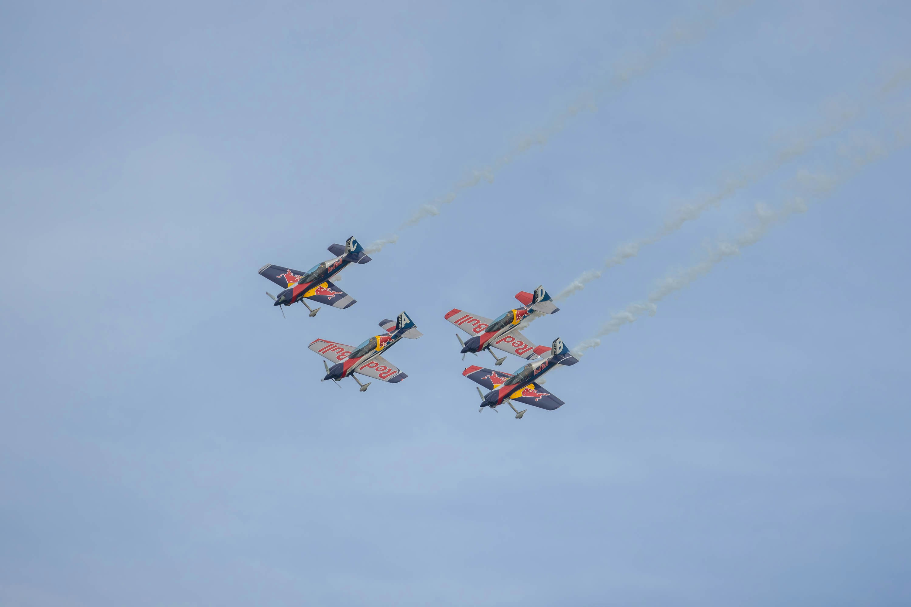 a group of airplanes flying through a blue sky