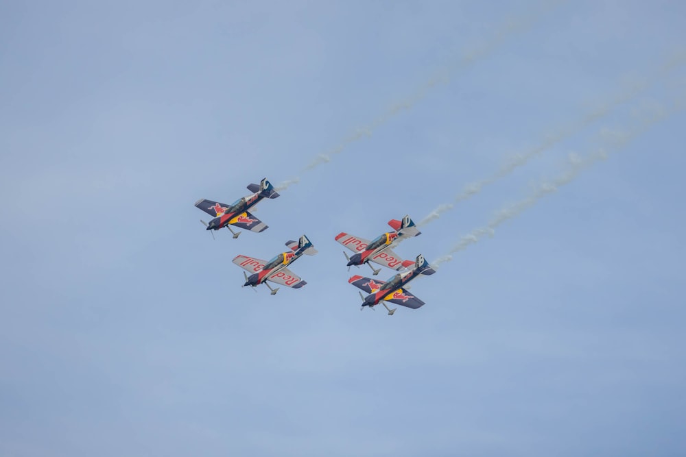 a group of airplanes flying through a blue sky