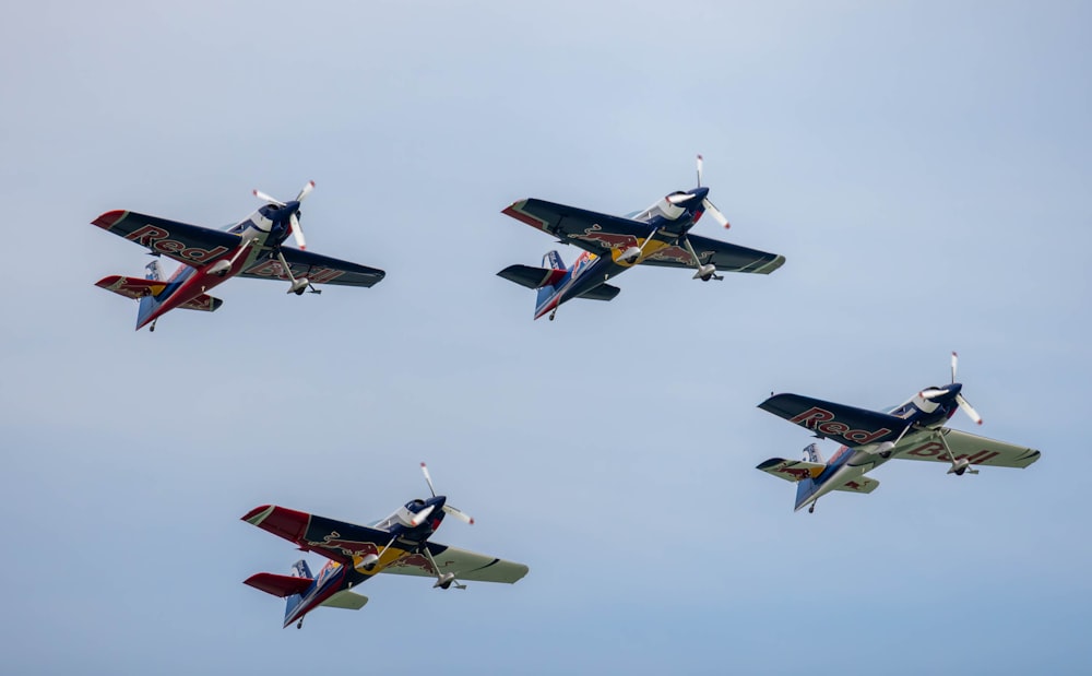 a group of four planes flying in the sky