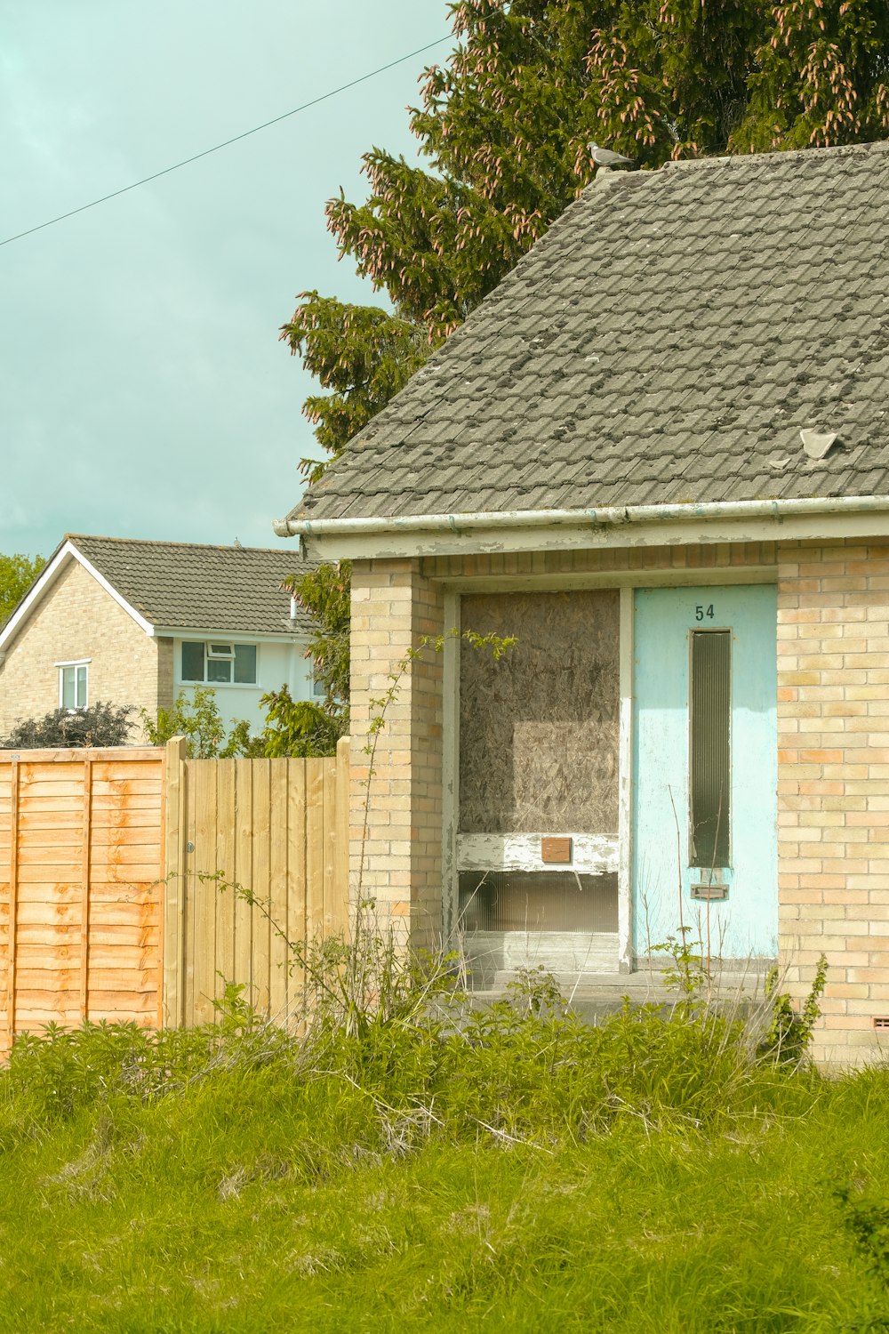 a small brick house with a blue door and window