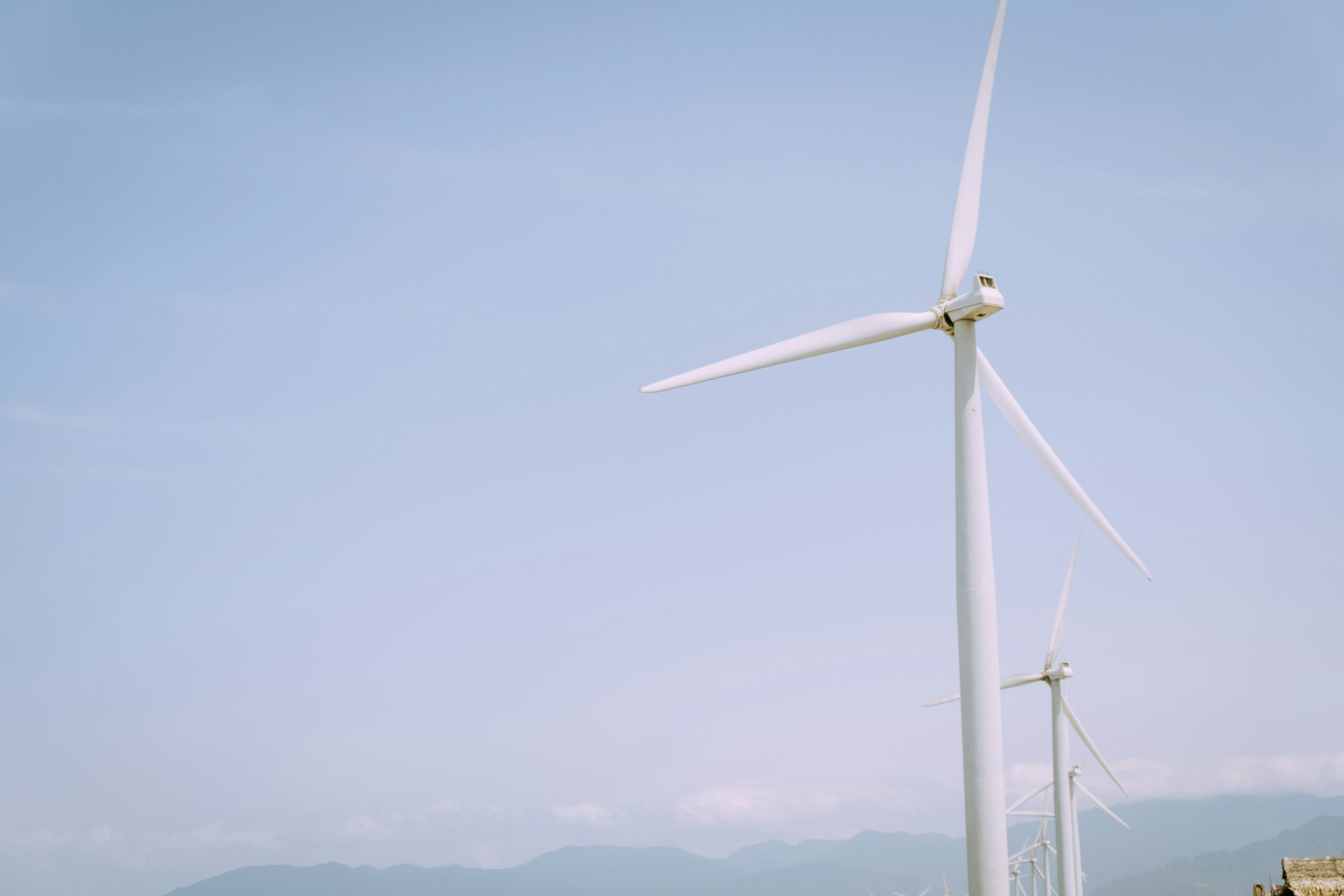 a group of windmills in a field with mountains in the background