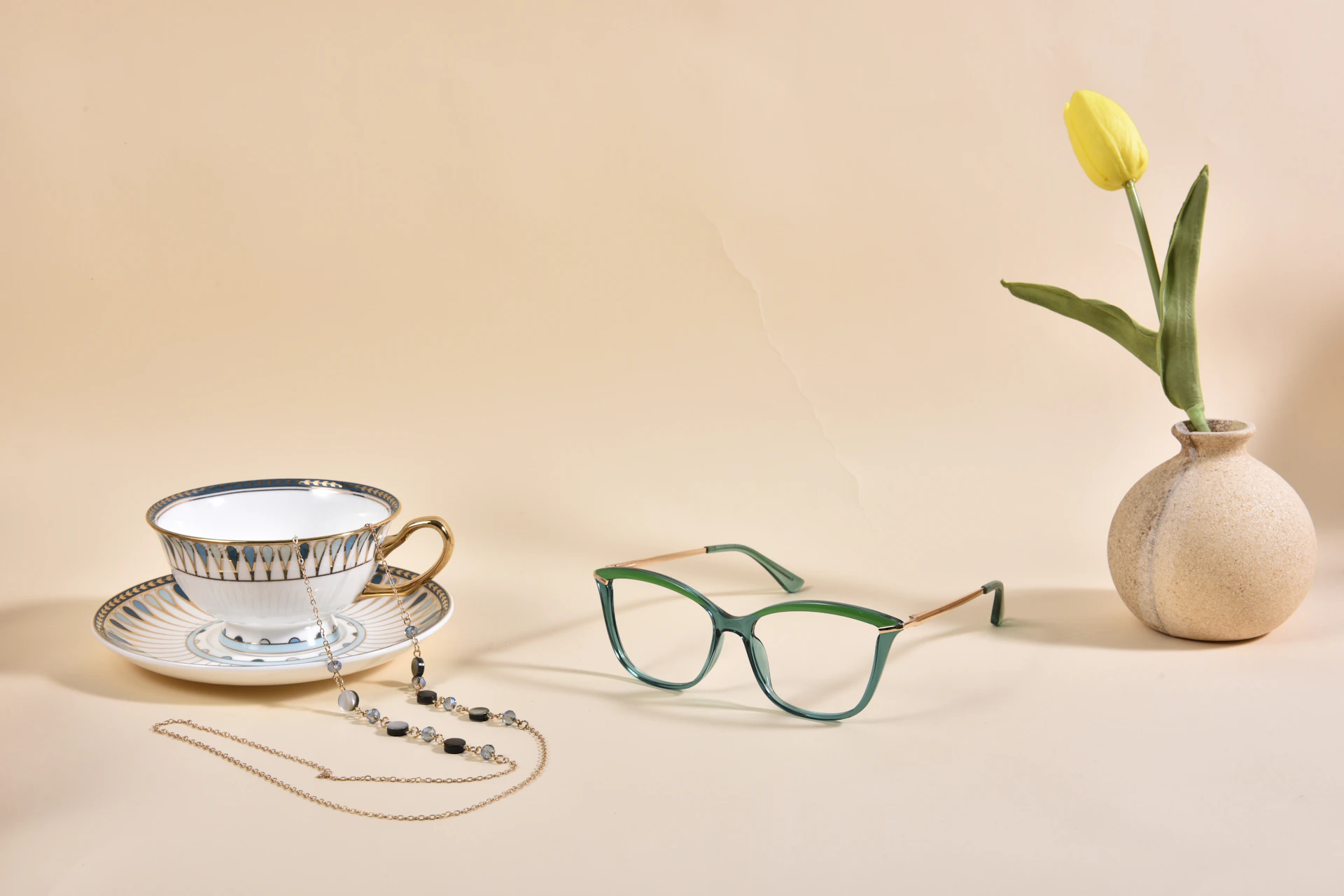 a vase with a flower and a pair of glasses