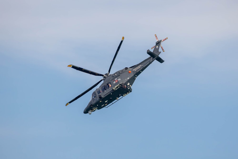 a helicopter flying through a blue sky on a sunny day