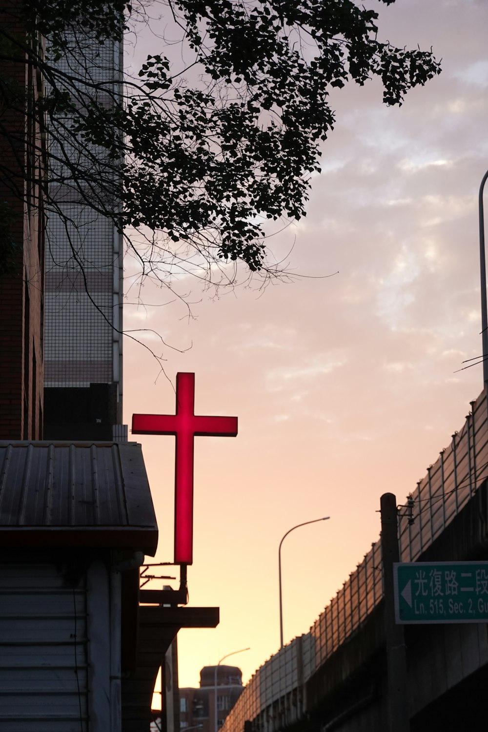 a large red cross hanging from the side of a building