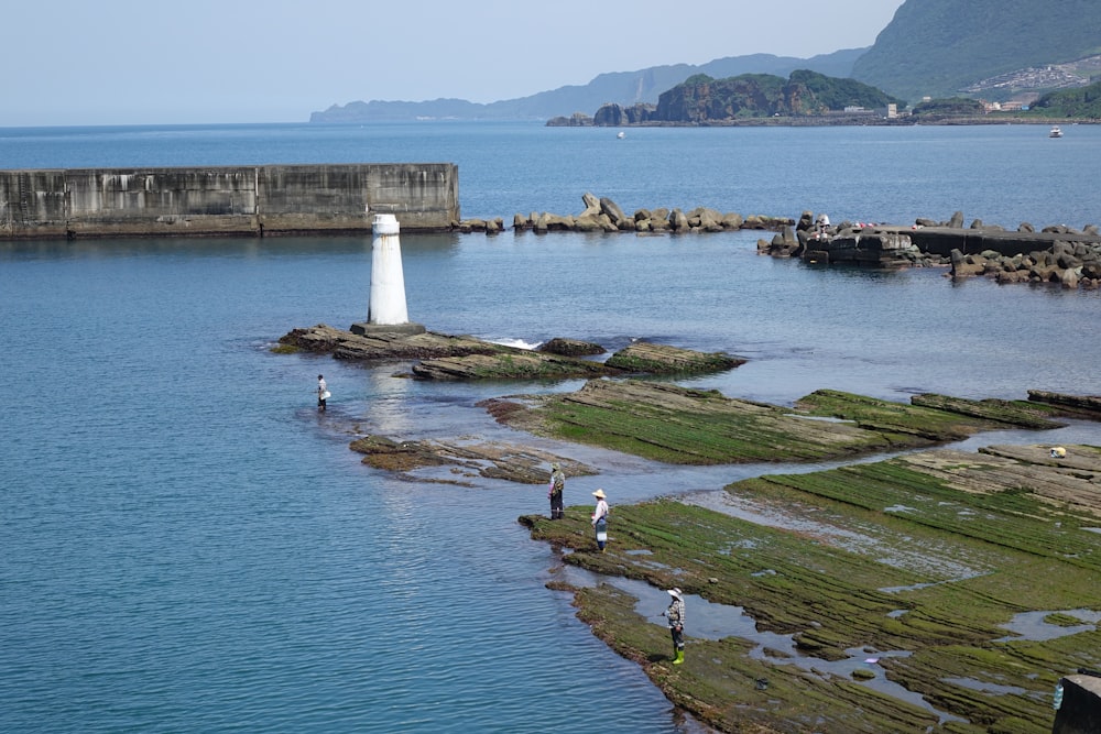 a group of people standing on top of a body of water