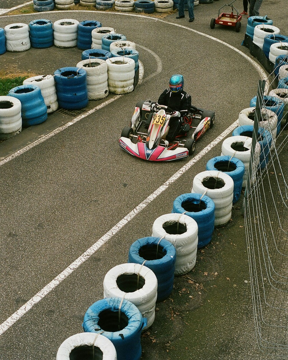 a man driving a kart with tires on the side of a road